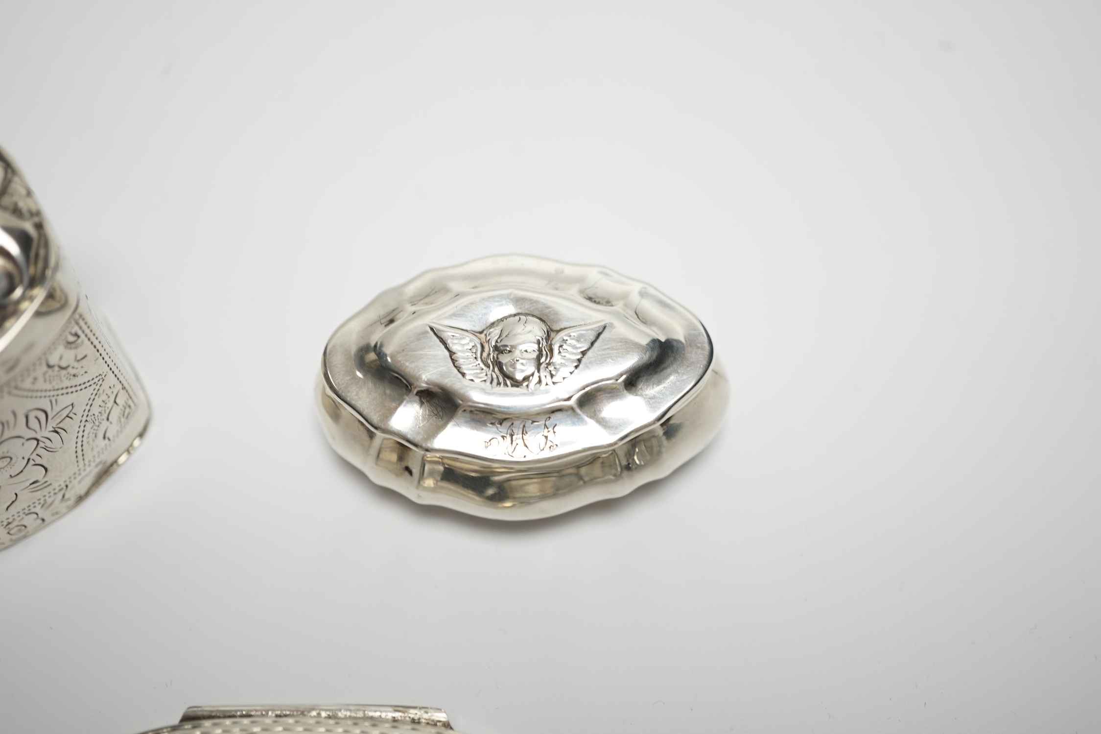 A late Victorian silver pill box with Reynold's Angel decorated cover, 47mm, a modern silver pill box and a Dutch white metal box.